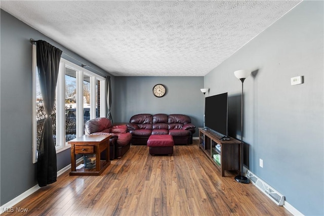 living room with hardwood / wood-style floors and a textured ceiling