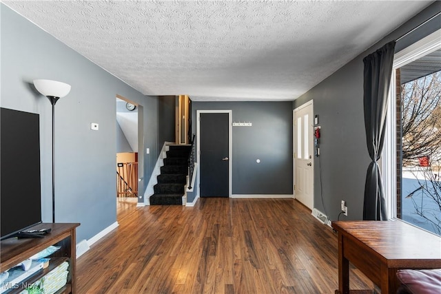 foyer with plenty of natural light, dark hardwood / wood-style flooring, and a textured ceiling