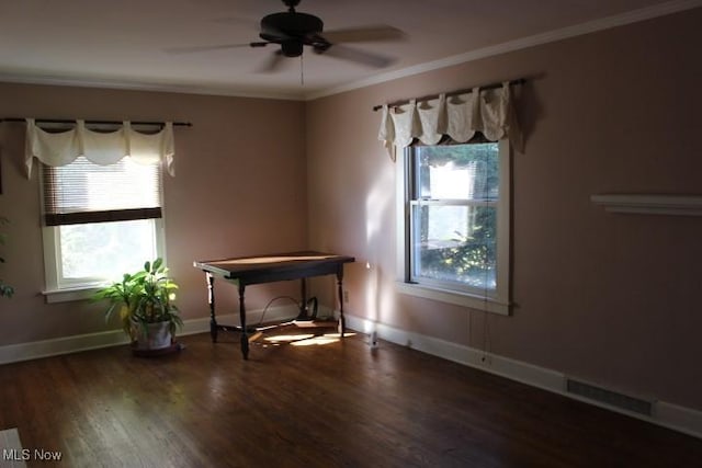 spare room featuring crown molding, ceiling fan, a healthy amount of sunlight, and dark hardwood / wood-style floors