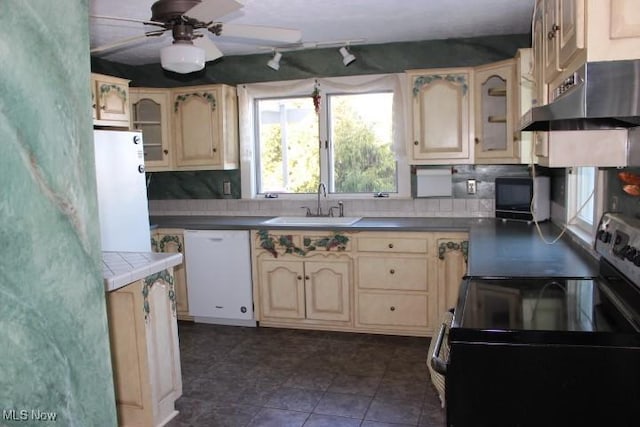 kitchen with sink, white appliances, backsplash, ceiling fan, and cream cabinetry