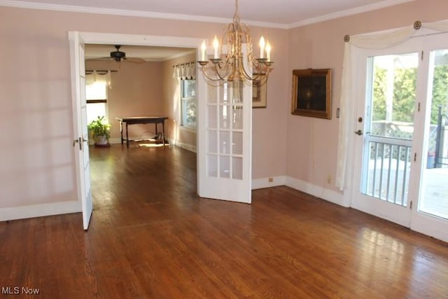 unfurnished dining area with ceiling fan with notable chandelier, dark wood-type flooring, and ornamental molding