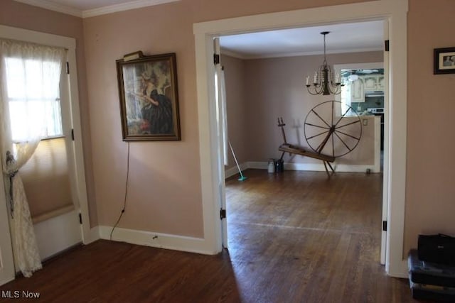 hallway featuring an inviting chandelier, ornamental molding, and dark hardwood / wood-style flooring