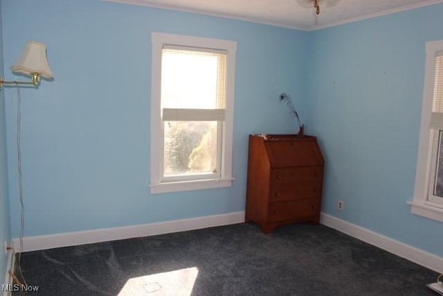 unfurnished bedroom with ornamental molding and dark carpet