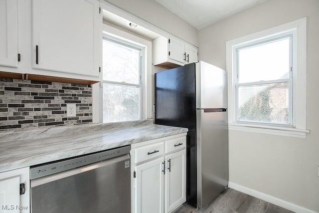 kitchen featuring dark wood-type flooring, appliances with stainless steel finishes, tasteful backsplash, and white cabinets