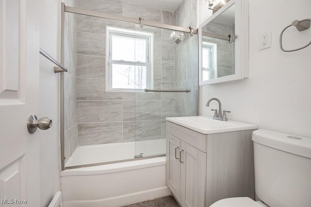 full bathroom with toilet, vanity, and bath / shower combo with glass door