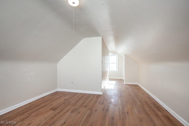 bonus room featuring hardwood / wood-style flooring and vaulted ceiling