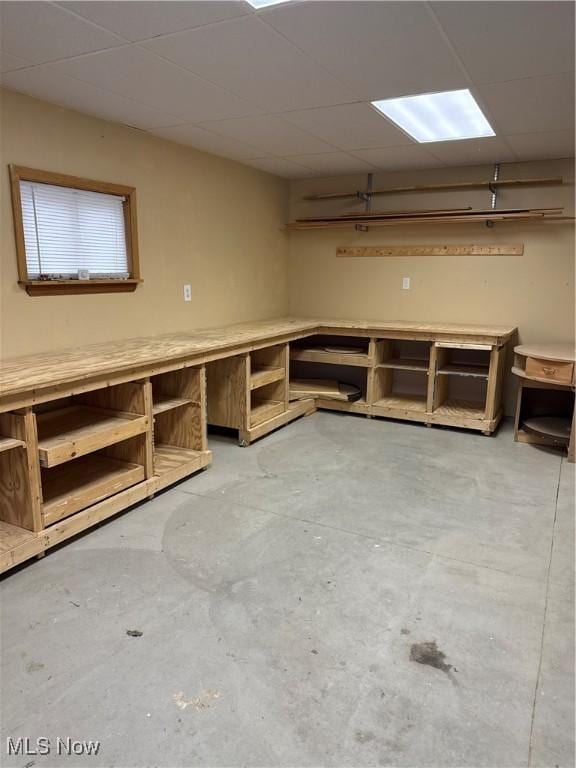 basement featuring a paneled ceiling and a workshop area