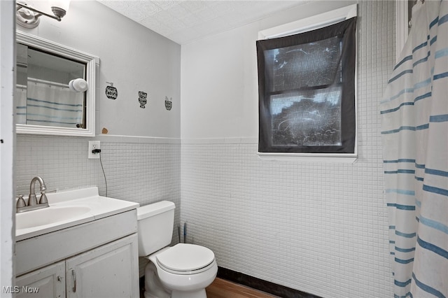 bathroom featuring vanity, toilet, a shower with shower curtain, and tile walls