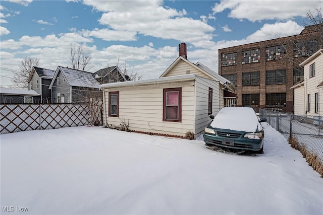 view of snow covered back of property