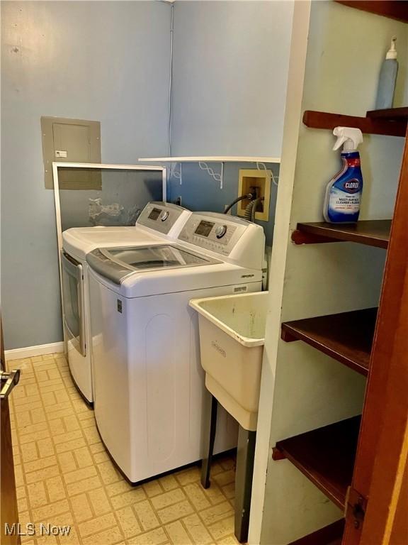 laundry room featuring electric panel and washing machine and clothes dryer