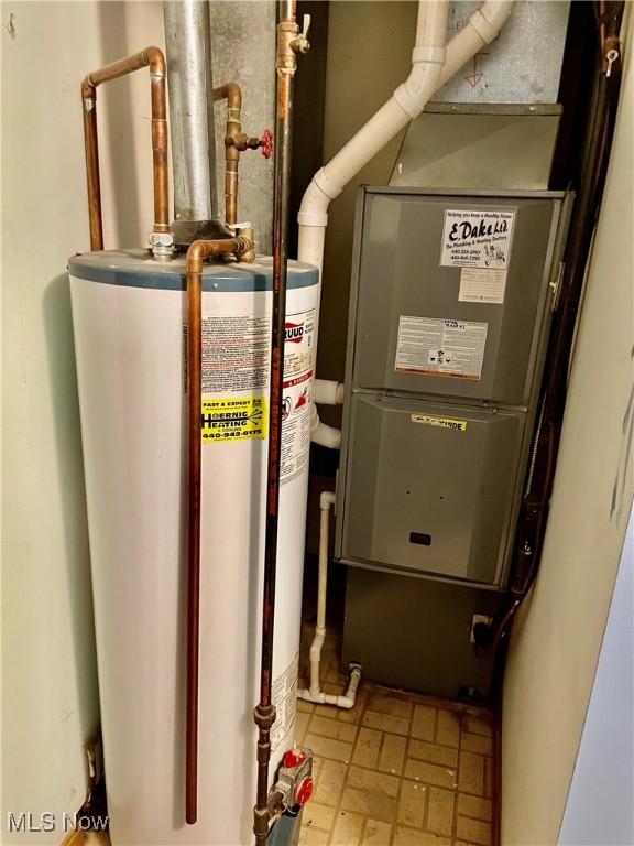 utility room with heating unit and water heater