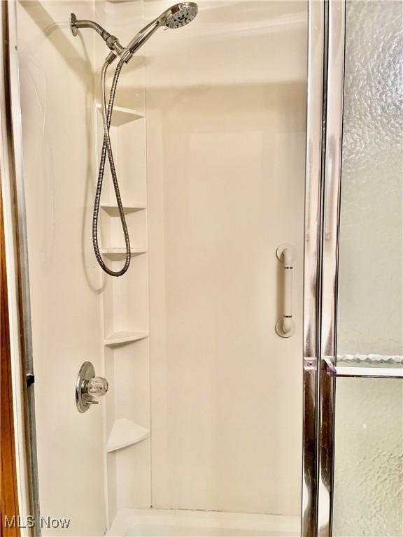 bathroom featuring a shower with door