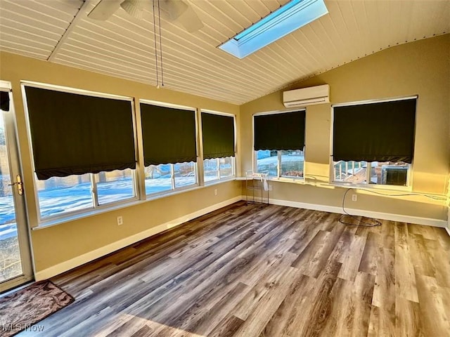 unfurnished sunroom featuring lofted ceiling with skylight, a wall mounted air conditioner, and ceiling fan