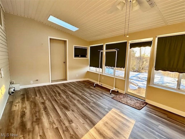 unfurnished room with hardwood / wood-style floors, vaulted ceiling with skylight, and ceiling fan