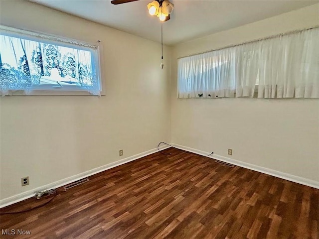 empty room with dark wood-type flooring and ceiling fan