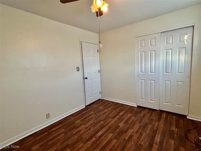 unfurnished bedroom featuring dark wood-type flooring, a closet, and ceiling fan