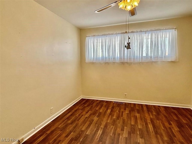 unfurnished room featuring dark wood-type flooring and ceiling fan