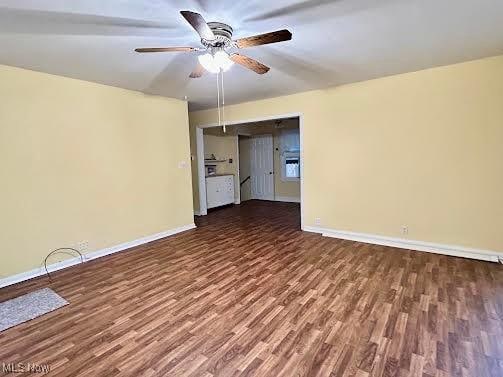 spare room with ceiling fan and dark hardwood / wood-style flooring