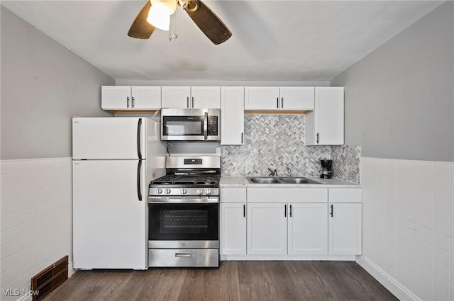 kitchen featuring stainless steel appliances, dark hardwood / wood-style floors, sink, and white cabinets