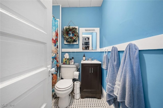 bathroom featuring vanity, walk in shower, and toilet