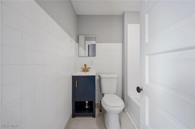 bathroom with tile patterned flooring, vanity, tile walls, and toilet