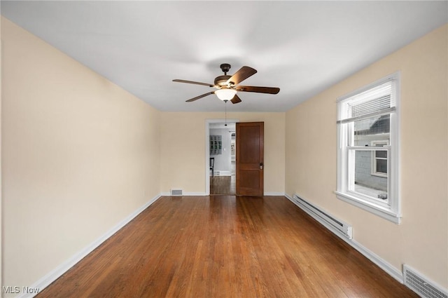 spare room featuring ceiling fan, baseboard heating, and light hardwood / wood-style floors