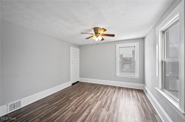 spare room with ceiling fan, dark hardwood / wood-style floors, and a textured ceiling