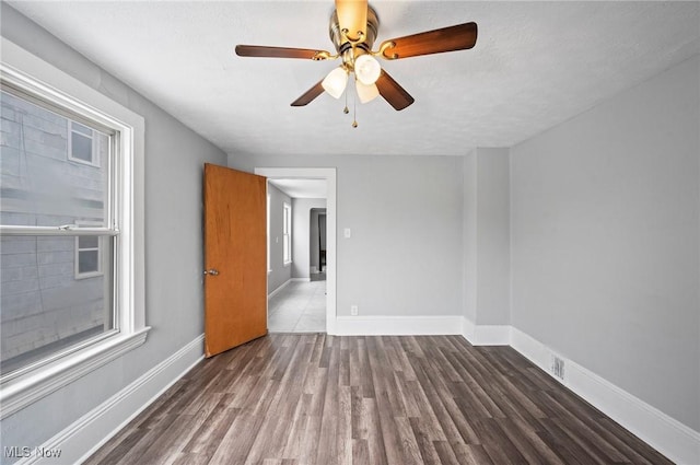 unfurnished room with dark hardwood / wood-style floors and ceiling fan