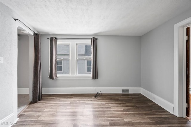 empty room featuring hardwood / wood-style floors and a textured ceiling