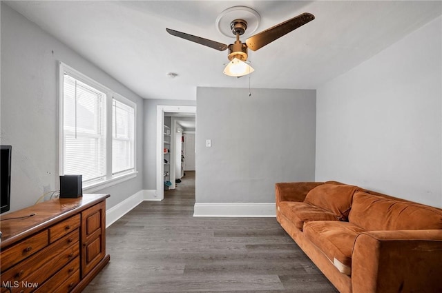 living room featuring ceiling fan and dark hardwood / wood-style flooring