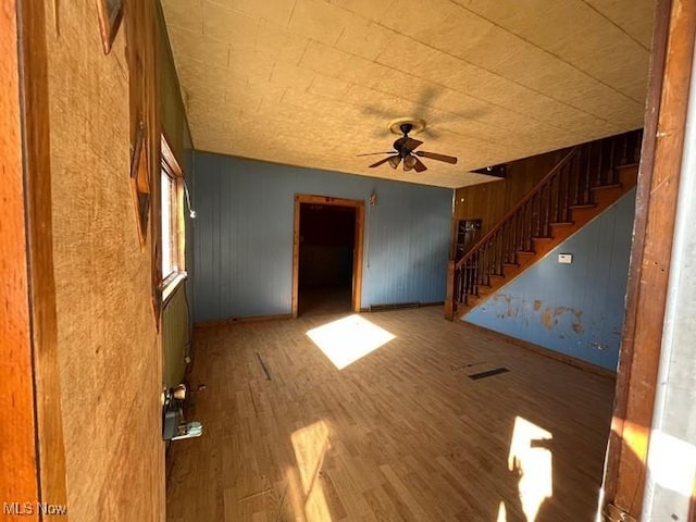 83 Watson St, Dillonvale, OH 43917 - unfurnished living room featuring stairs, a ceiling fan, and wood finished floors