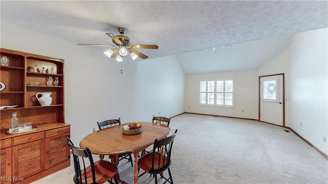 carpeted dining room with vaulted ceiling, ceiling fan, and a textured ceiling