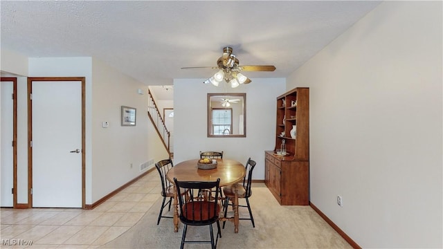 dining space with ceiling fan and a textured ceiling