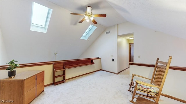 living area featuring light colored carpet and lofted ceiling with skylight