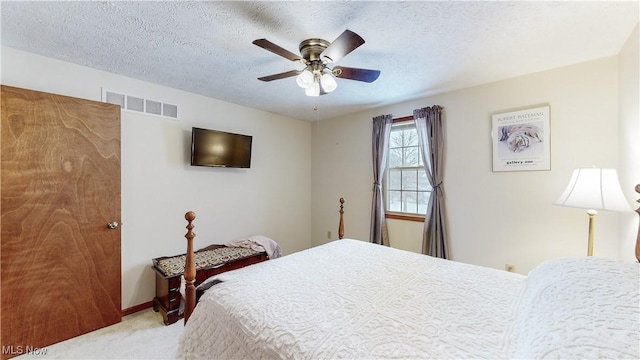 carpeted bedroom featuring a textured ceiling and ceiling fan