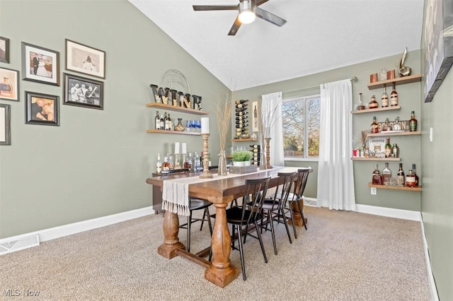 dining room with vaulted ceiling, ceiling fan, bar, and carpet floors