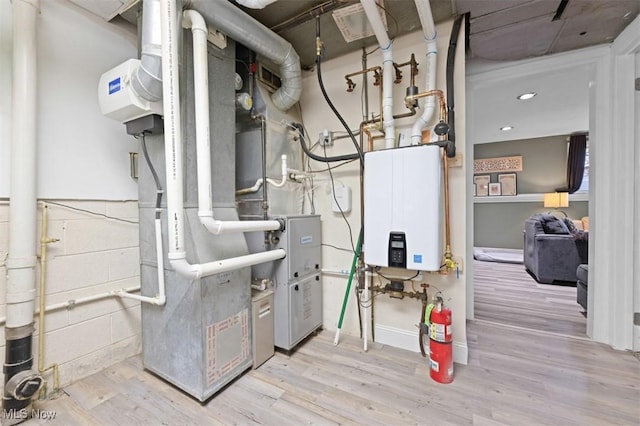 utility room with heating unit and tankless water heater