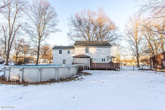 snow covered back of property with a gazebo and a swimming pool side deck