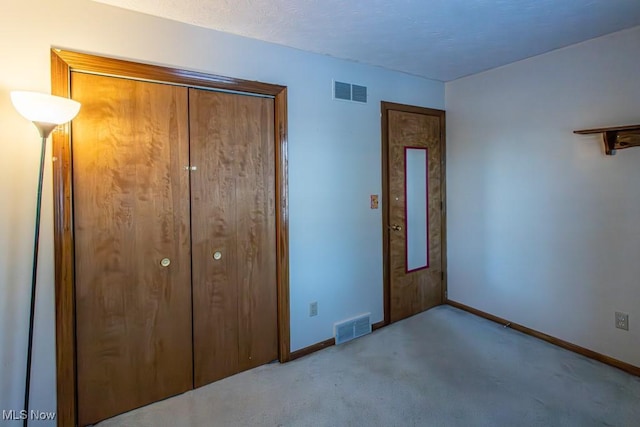 unfurnished bedroom with light carpet and a closet