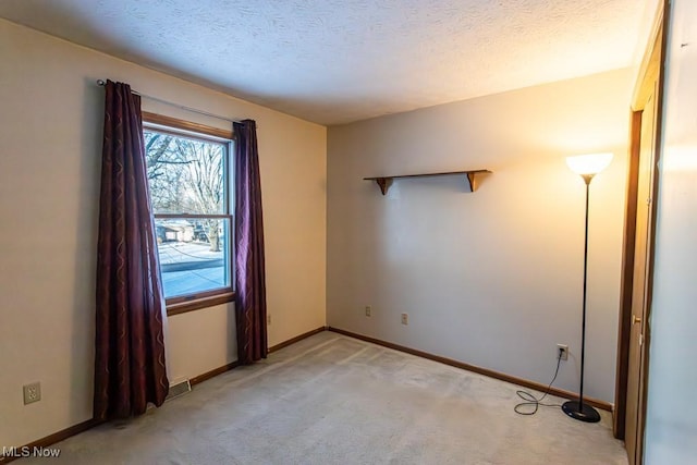 carpeted spare room with a textured ceiling