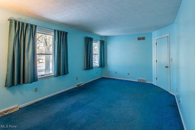 carpeted spare room featuring a textured ceiling