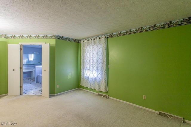 carpeted spare room featuring a textured ceiling