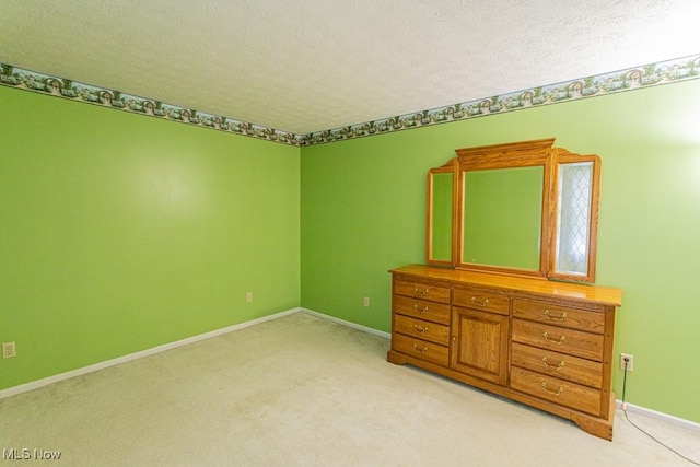 unfurnished bedroom featuring light colored carpet and a textured ceiling