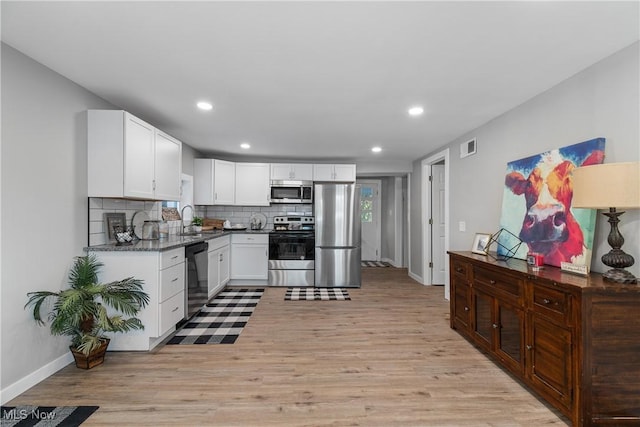 kitchen with white cabinetry, appliances with stainless steel finishes, sink, and light wood-type flooring