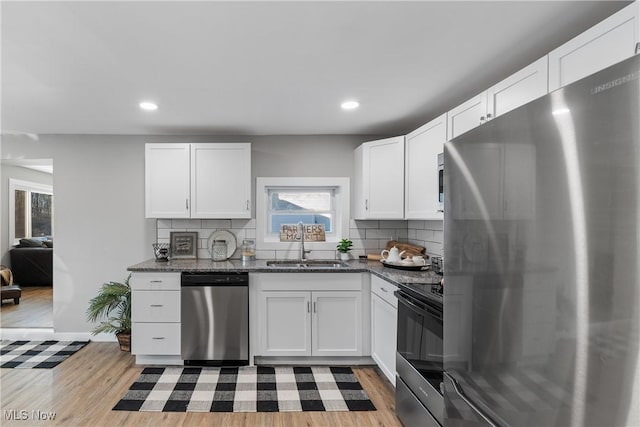 kitchen featuring appliances with stainless steel finishes, sink, and white cabinets