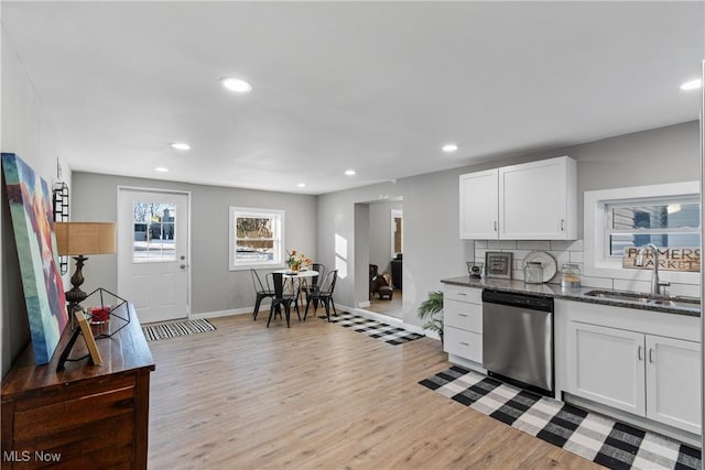 kitchen with white cabinets, light hardwood / wood-style floors, sink, and dishwasher