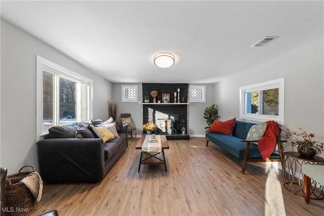 living room featuring a brick fireplace and hardwood / wood-style floors