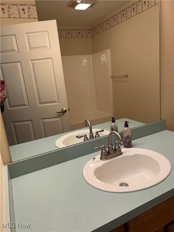 bathroom featuring vanity and a shower