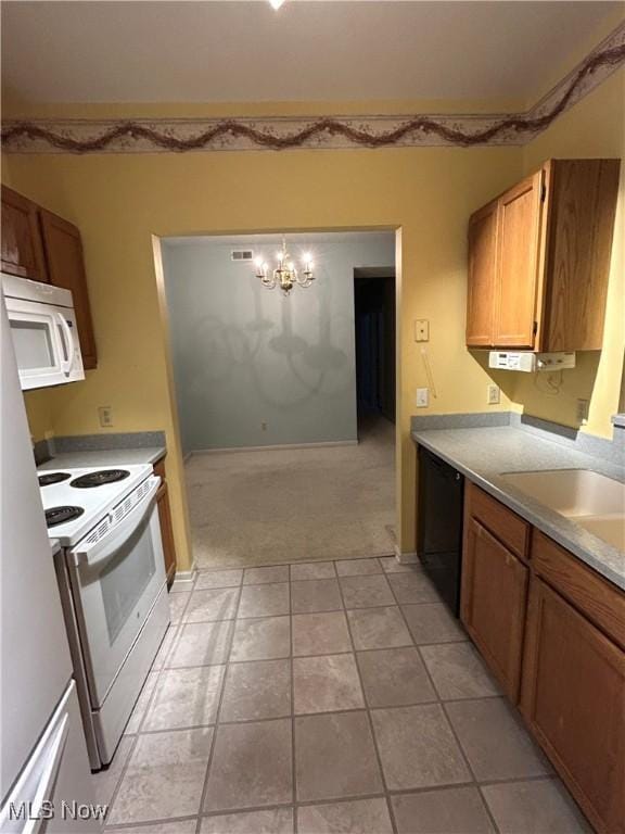 kitchen featuring sink, a chandelier, hanging light fixtures, light carpet, and white appliances