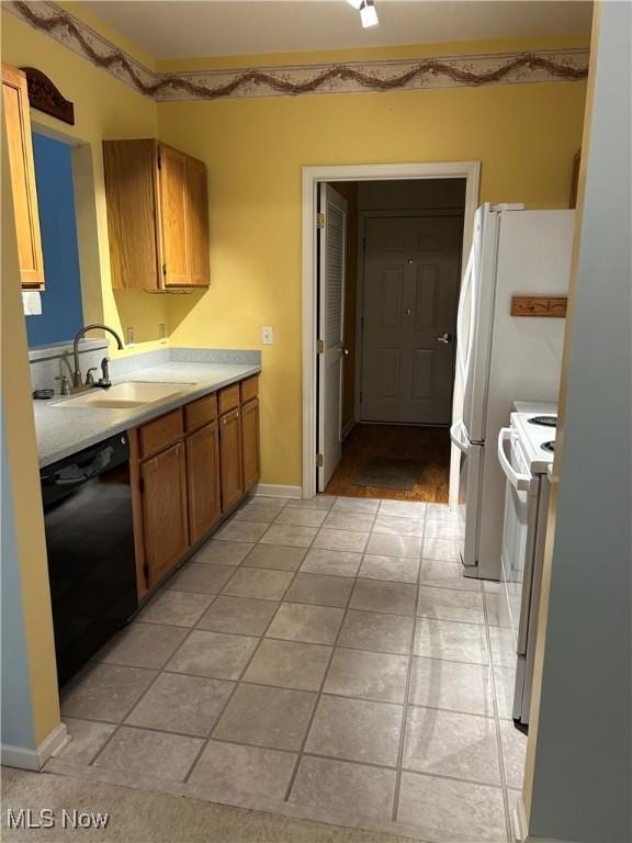 kitchen featuring dishwasher, sink, light tile patterned flooring, and white range with electric cooktop